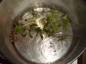 Kräuter-Salzlake zum Fermentieren der Schlehen kochen.