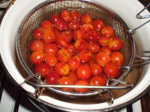 Kandierte Kriecherln im neuen Sirup kochen.