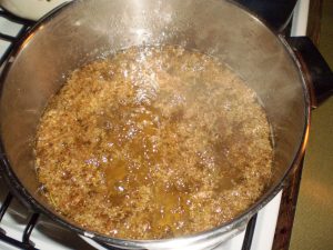 Ansatz für Mädesüßsirup mit Blüten aufkochen.