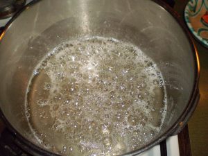 Zuckerlösung für kandierte Kriecherln kochen.