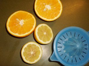 Eine Zitrone und eine Orange auspressen